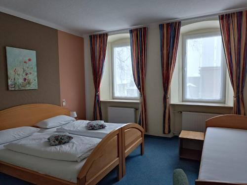 1 dormitorio con 2 camas y 2 ventanas en Garni Hotel Post, en Weissenstadt
