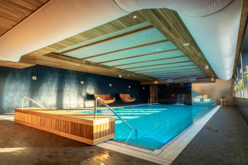 a large swimming pool in a large room with a large at Ö Seaside Suites & SPA in Kuressaare