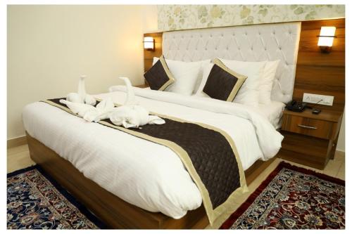 a bedroom with two large beds with white sheets at Hotel Signature Prime Vaishali Nagar Jaipur in Jaipur