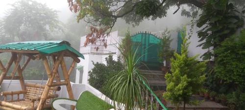 a garden in the rain with a gazebo and chairs at Experto The Greens in Nainital