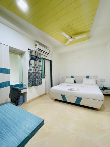 a bedroom with a bed and a desk in it at Hotel Holiday Pride in Aurangabad