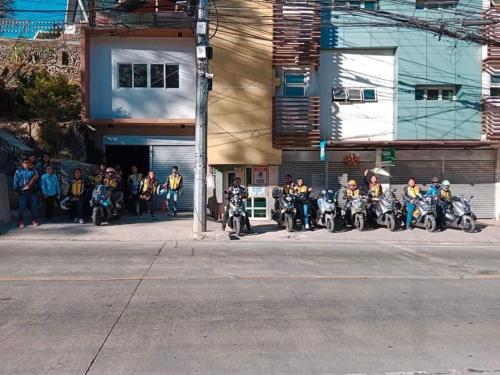 碧瑤的住宿－Aussie Inn Baguio City Direct，停在大楼前的一组摩托车