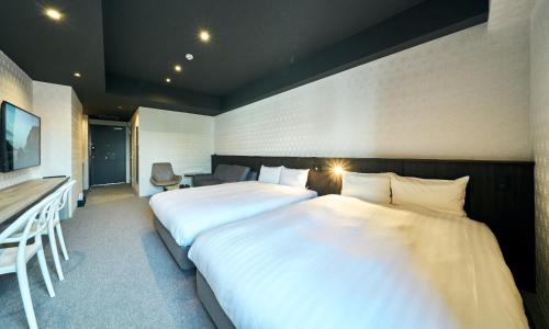 a hotel room with two beds and a desk at Rakuten STAY Kokura Station Standard Twin Room with counter table in Kitakyushu