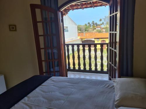 a bedroom with a bed and a view of a balcony at Pousada Amarela Cabo Frio in Cabo Frio