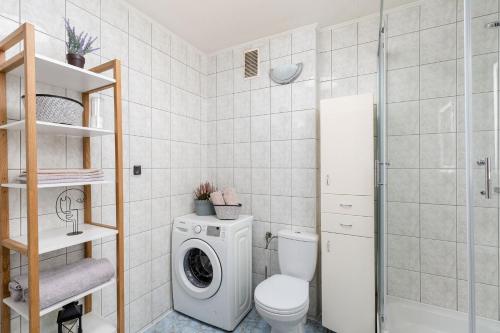 ein Badezimmer mit einem WC und einer Waschmaschine in der Unterkunft Apartament z parkingiem Zakopane in Zakopane
