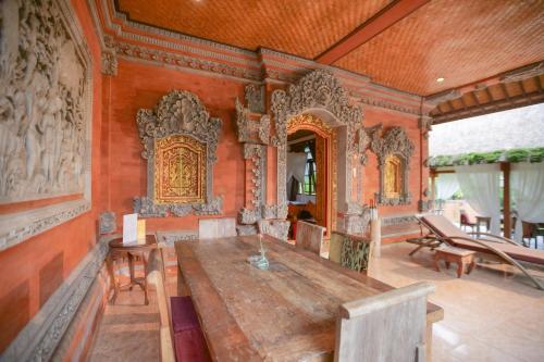 a dining room with a wooden table and chairs at Gayatri in Ubud