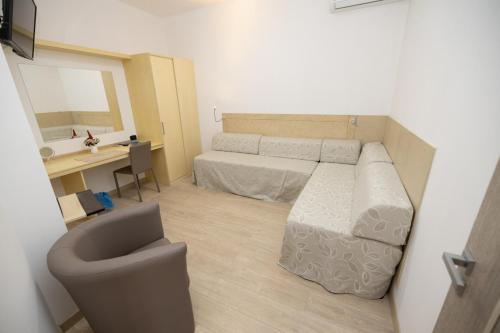 IoppoloにあるArenas Hotelのベッドとデスクが備わる小さな客室です。