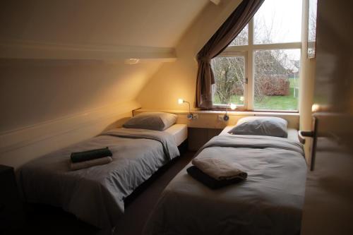 - 2 lits dans une chambre avec fenêtre dans l'établissement Holiday home Sunset, à Noordwijkerhout