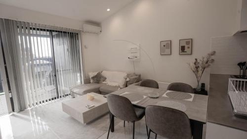 a white living room with a table and chairs at N vacation stay サウナBBQ付き一棟貸ヴィラ2名2万から ペット可 100インチ超え大画面シアター in Ichinomiya