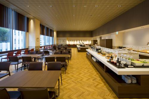 a restaurant with tables and chairs and a buffet at Hotel Monterey Fukuoka in Fukuoka