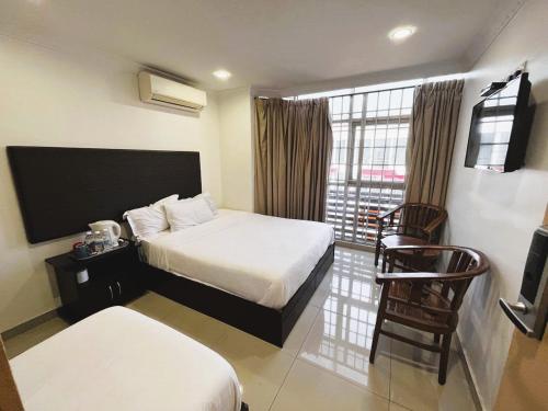 a hotel room with two beds and a balcony at Hotel Sagittario in Ipoh