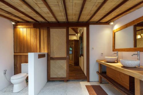 a bathroom with a toilet and a sink at Villa Terra in Gili Trawangan
