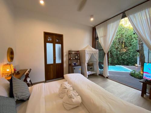 a bedroom with a large bed with towels on it at Proud Phu Fah Maerim Resort in Mae Rim