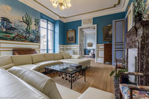 a living room with blue walls and a couch and a table at Bonjour Guesthouse in Nevers
