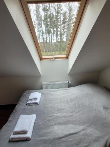 a bedroom with a bed with two towels on it at Willa Poziomka, Mielno, Grunwald in Mielno
