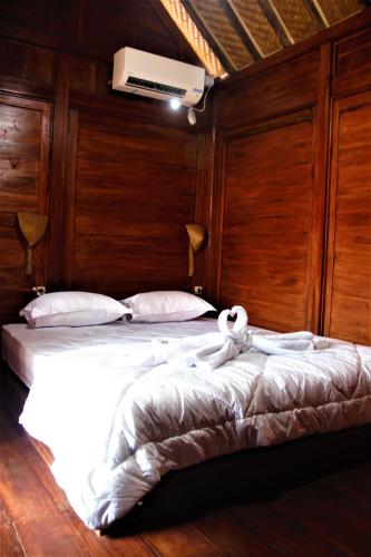 a bedroom with a large bed with white sheets at Wisma Andany in Jepara