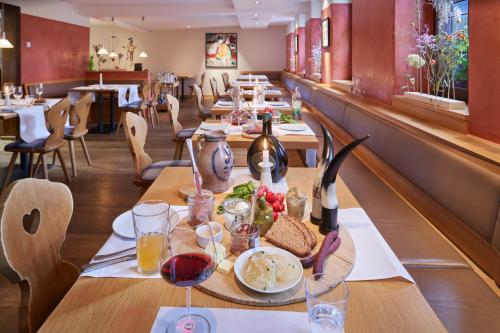 a restaurant with a table with food and wine at Hotel Zum Goldenen Ochsen am Schlossgarten in Aschaffenburg