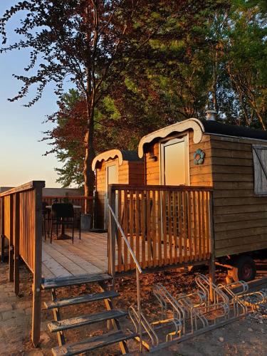 a wooden cabin with a porch and a deck at The Cuckoo's nest in Amsterdam