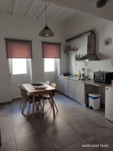 una cucina con tavolo e sedie in una stanza di Smyrnis Apartments a Ermoupoli