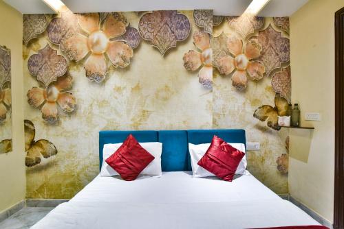 a bedroom with a bed with red and white pillows at Hotel Singh International, Amritsar in Amritsar