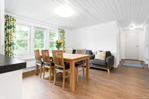 a dining room with a table and chairs and a couch at First Camp Nydala-Umeå in Umeå