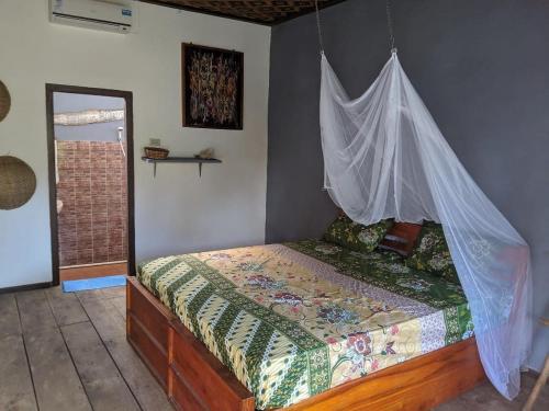 um quarto com uma cama e uma rede mosquiteira em C Point Krui em Krui