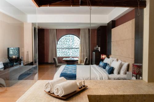 um quarto com uma cama grande e uma janela grande em Grand City Hall Hotel & Serviced Residences em Medan