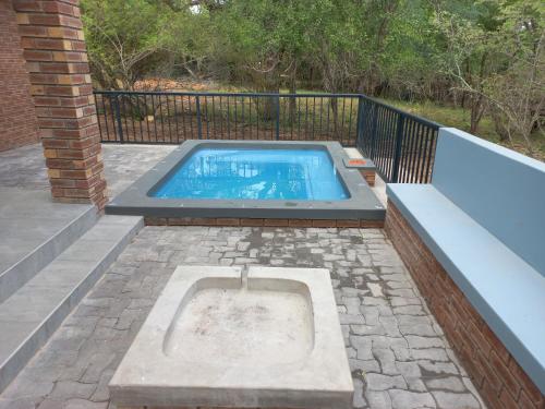 a swimming pool on a patio with a fence at Make a memory in Marloth Park
