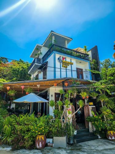 a building with plants in front of it at Monkey Homestay & Bar in Tân Hiệp