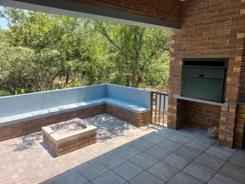 a patio with a hot tub in a brick building at Make a memory in Marloth Park