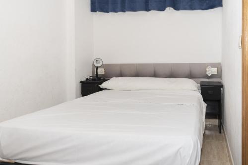 a bedroom with a white bed and a window at Lider, 44-E (Planta Baja) in Cullera