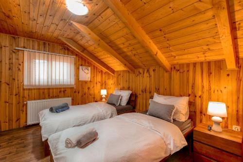 two beds in a room with wooden walls at Holiday home Palo santo in Gospić