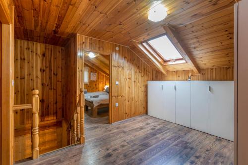 a room with wooden walls and a ceiling with a skylight at Holiday home Palo santo in Gospić