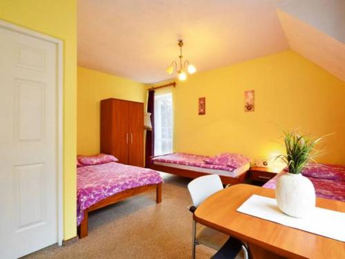 Pokój z 2 łóżkami, stołem i biurkiem w obiekcie Villa Mariano w Piechowicach