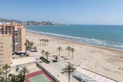 a view of a beach with palm trees and the ocean at LIDER, 12º-A Atico in Cullera