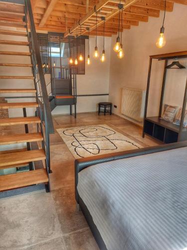 a room with a bed and a staircase in it at L'accoté Chambre d'hotes La grange de Battignies in Binche