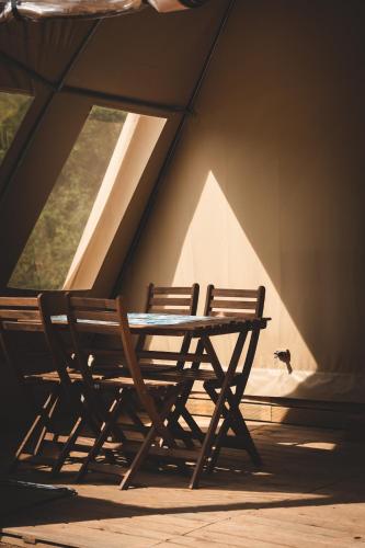 two wooden benches sitting in a room with windows at Verblijfpark Ardinam in Olloy-sur-Viroin