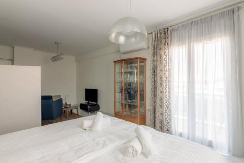 een slaapkamer met een groot wit bed en een raam bij Elegant Apartment With Acropolis View in Athene