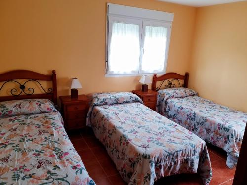 a bedroom with two beds and a window at Casa César in Barreiros