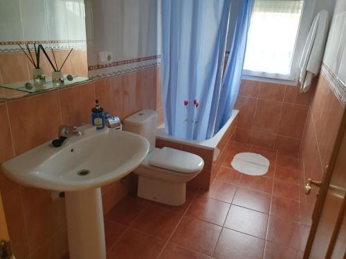 a bathroom with a sink and a toilet and a window at Casa César in Barreiros