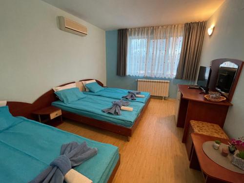 1 dormitorio con 2 camas, escritorio y TV en Bar & Guests room ELA, en Dolen Bliznak