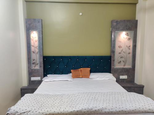 een slaapkamer met een groot bed met een blauw hoofdeinde bij Om Paradise in Ujjain