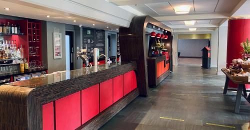 a bar in a restaurant with a red counter at The Lincoln Hotel in Lincoln