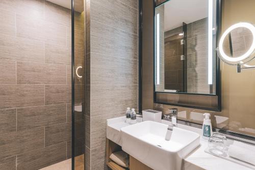 a bathroom with a sink and a mirror at Shanghai Atour Hotel On The Bund- People Square in Shanghai