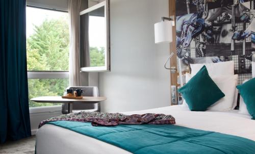 Un dormitorio con una cama con almohadas verdes y una ventana en Demeures de Campagne Château de Fontainebleau, en Fontainebleau