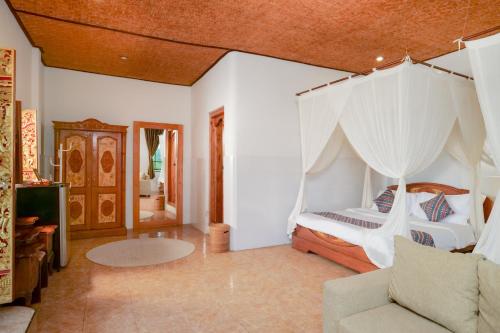 a bedroom with a bed with a white canopy at Gayatri in Ubud