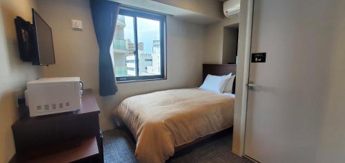 a hotel room with a bed and a window at HOTEL LiVEMAX Kamata Ekimae in Tokyo