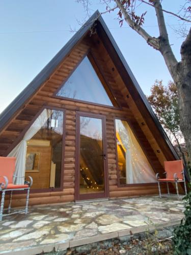 a frame house with a glass door and two chairs at Agora Farmhouse in Koman