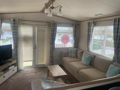 sala de estar con sofá y TV en Luxury 6 Berth Caravan, Marton Mere, en Blackpool