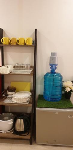 a shelf with a blue jug on top of a refrigerator at Tacloban EVMC Gdex Transient House in Tacloban